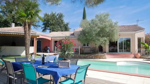 - une table et des chaises à côté de la piscine dans l'établissement Les Gîtes de Bellevue, à Nueil-sous-les-Aubiers