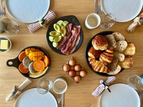 een houten tafel met borden ontbijtproducten erop bij Hilltop Enchanting Villa with Stunning Views & Jacuzzi in Medellín