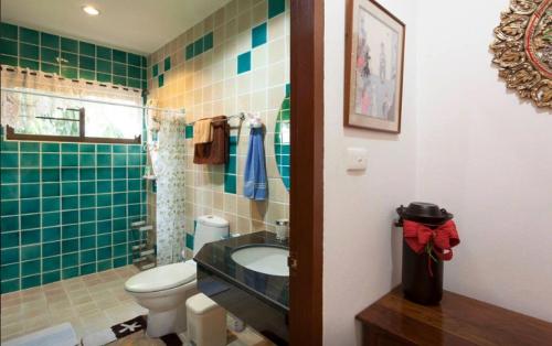 a bathroom with a sink and a toilet and green tiles at HomeSweetHome in Hang Dong