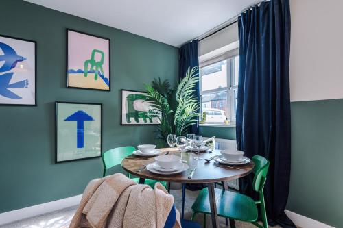 a dining room with a table and green chairs at Lovely 3 Bedroom House in Grimsby with WiFi & Parking Sleeps7 by PureStay in Grimsby