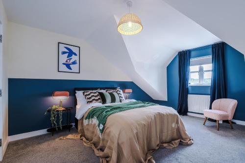 a blue bedroom with a bed and a chair at Lovely 3 Bedroom House in Grimsby with WiFi & Parking Sleeps7 by PureStay in Grimsby