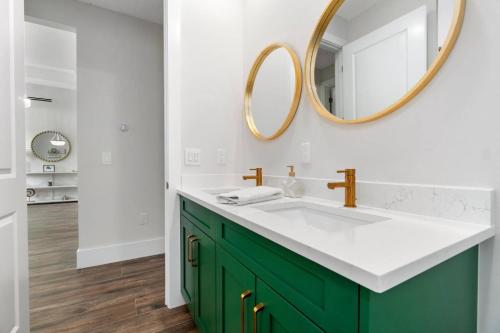 a bathroom with a green vanity and a mirror at Deja Blu in Marco Island