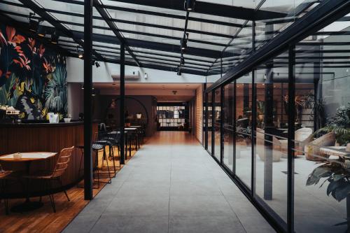 a restaurant with glass walls and tables and chairs at Deco Collection in Buenos Aires