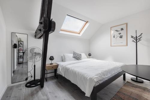 a white bedroom with a bed and a table at Cosy Place Brussels Expo 200 in Brussels