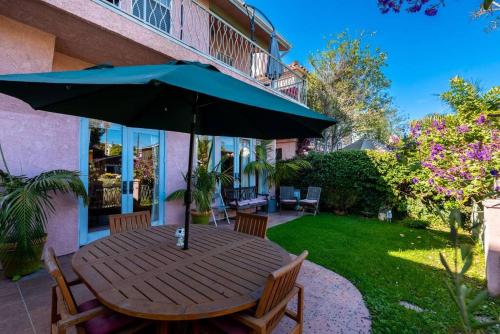 a wooden table with an umbrella in a yard at House on the canal in Venice in Los Angeles