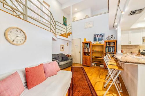 a living room with a couch and a clock on the wall at House on the canal in Venice in Los Angeles