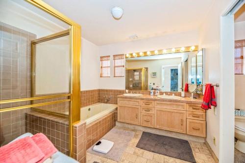 a bathroom with a tub and a large mirror at House on the canal in Venice in Los Angeles