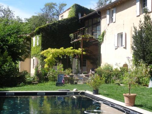 une maison avec une piscine en face d'une cour dans l'établissement Le Vieux Moulin, au Tholonet
