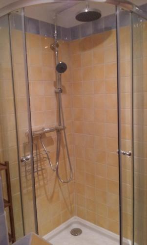 une douche avec une porte vitrée dans une salle de bain dans l'établissement Le Vieux Moulin, au Tholonet