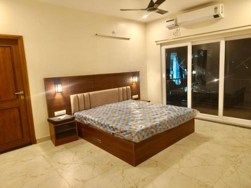 a bedroom with a bed and a window at Famval Serviced Apartment in Tiruchchirāppalli