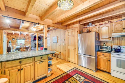 a kitchen with wooden cabinets and a stainless steel refrigerator at Near Bushkill Falls Pocono Mountains Cabin! in Bushkill