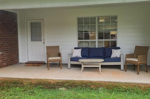 a blue couch sitting on a porch with two chairs at EastGate 11B in Hammond