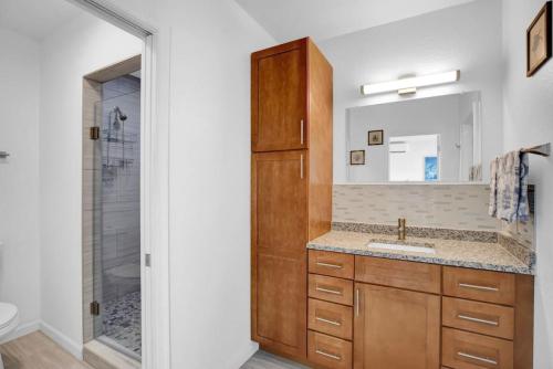 a bathroom with a sink and a shower with a mirror at Blue Octopus Hideaway at OI in Marathon