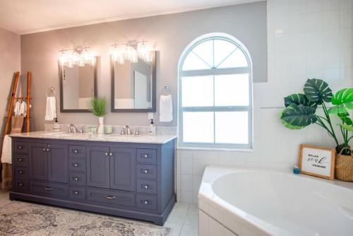 a bathroom with two sinks and a tub and a window at Oceans Edge Retreat in Key Colony Beach