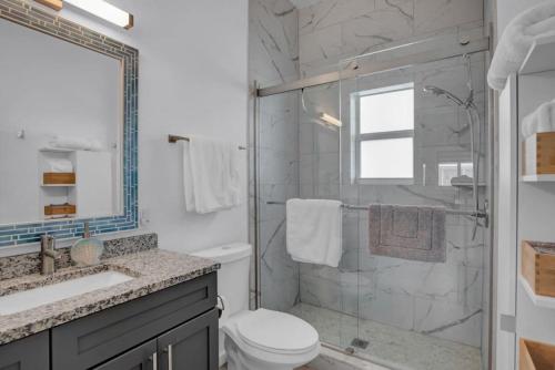 a bathroom with a shower and a toilet and a sink at Oceanside Spacious Studio Escape in Marathon