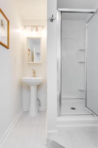 a white bathroom with a sink and a shower at Sweet Tea Cottage 1BR and Loft in Murfreesboro