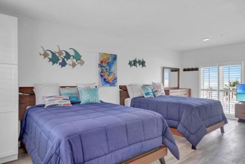 two beds in a room with purple sheets at Panoramic Ocean Views Galore in Marathon