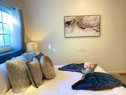 a bed with pillows and a vase of flowers on it at New Charming Spacious Disneyland Pool Home in Garden Grove