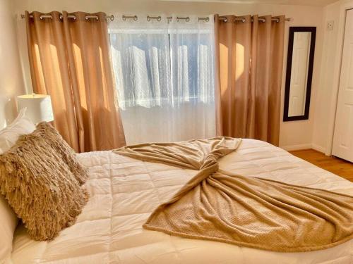 a bed with a blanket on it in a bedroom at New Charming Spacious Disneyland Pool Home in Garden Grove