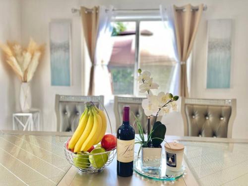 a bowl of fruit and a bottle of wine on a table at New Charming Spacious Disneyland Pool Home in Garden Grove