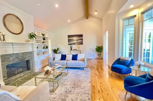 a living room with blue chairs and a fireplace at New Charming Spacious Disneyland Pool Home in Garden Grove