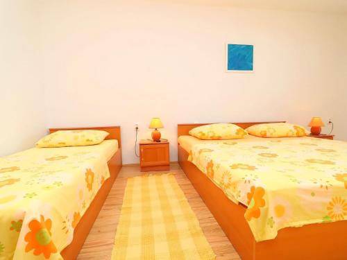 - une chambre avec 2 lits avec des draps jaunes dans l'établissement Apartments Stipo - Comfort One Bedroom Apartment with Terrace and Sea View A1, à Drače