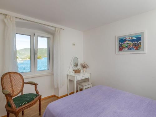 une chambre avec un lit, une chaise et une fenêtre dans l'établissement Holiday Home Anima Maris- Duplex Two Bedroom Holiday Home with Terrace and Sea View, à Ston