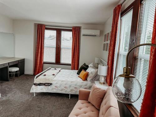 a bedroom with a bed and a couch and windows at Old World Charm River Views in Lewiston