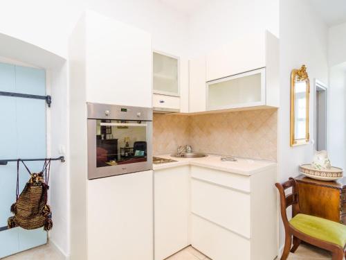 a kitchen with white cabinets and a sink at Stone House ''DiMaTo'' - Four Bedroom Holiday Home with Terrace in Gruda