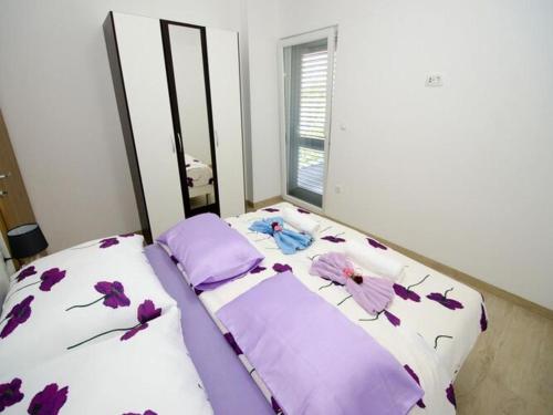 a bed with purple sheets and purple flowers on it at Apartments Vesela - Comfort One Bedroom Apartment with Balcony and Sea View in Janjina