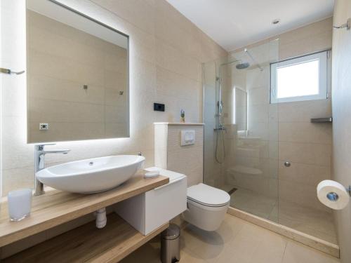 a bathroom with a sink and a toilet and a shower at Apartments Ema-Comfort Two Bedroom Apartment with Sea View Fancy in Rogotin