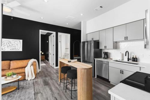 a kitchen and living room with a table and a couch at Chic Music Row Condo Rooftop Deck with City View Gym Office and More in Nashville