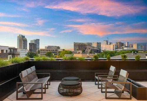 a balcony with chairs and a view of a city at Chic Music Row Condo Rooftop Deck with City View Gym Office and More in Nashville