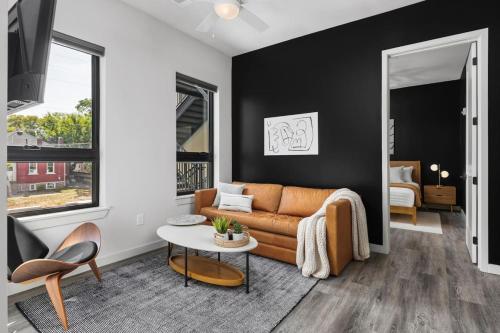 a living room with a couch and a table at Chic Music Row Condo Rooftop Deck with City View Gym Office and More in Nashville