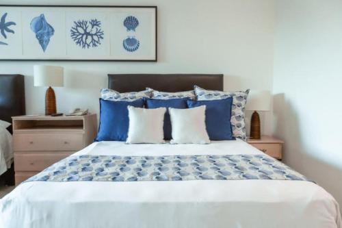 una camera da letto con un letto con cuscini blu e bianchi di Beachfront, Premium Ocean View, 5 Star, VLE 1604 a Cabo San Lucas