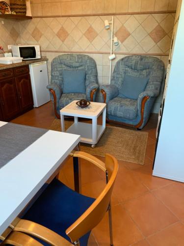 a living room with two chairs and a table at AL Ribeirinho in Mértola