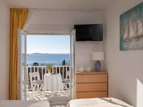 a bedroom with a bed and a balcony with a table at 2 room apartment with hot tub in Mlini