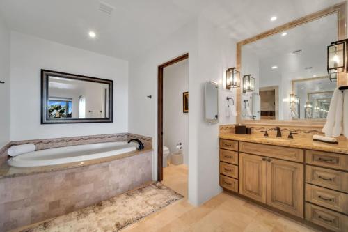 a bathroom with a tub and a large mirror at 2 BD 5-Star Beachfront Paradise in Cabo San Lucas