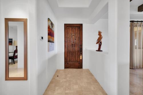 a hallway with a mirror and a wooden door at 2 BD 5-Star Beachfront Paradise in Cabo San Lucas