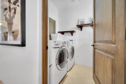 a white washer and dryer in a room at 2 BD 5-Star Beachfront Paradise in Cabo San Lucas