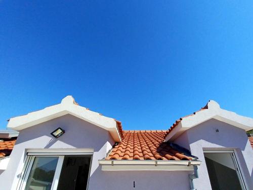 a white house with a red tile roof at Bertie's Lodge - Two Bedroom Apartment with Terrace and Sea View A1 in Smokvica