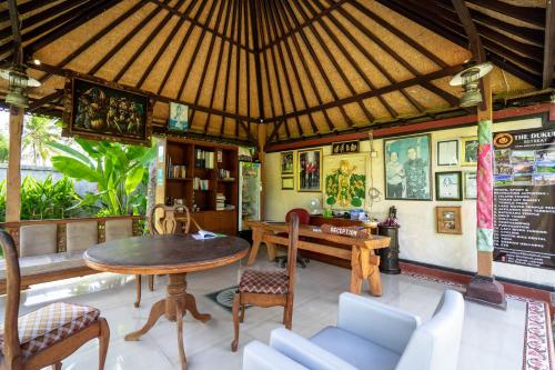 a dining room with a table and chairs in a room at The Dukuh Retreat in Tabanan