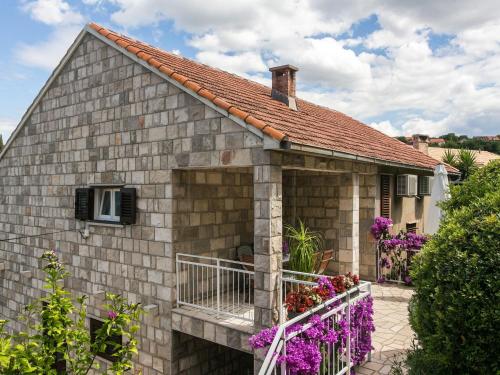 a brick house with purple flowers in front of it at Apartments Maria Kolo ep- Studio Apartment with Terrace and Sea View in Koločep