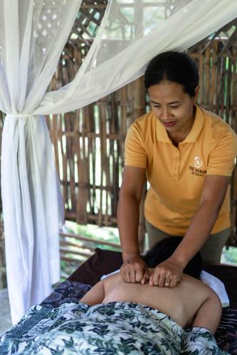 a man getting a massage on a mans back at The Dukuh Retreat in Tabanan