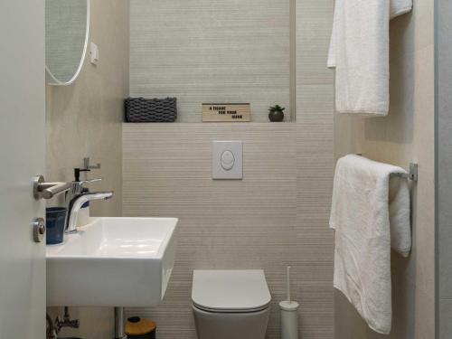 ein kleines Badezimmer mit Waschbecken und Toilette in der Unterkunft Apartments aMare - Three Bedroom Apartment with Terrace and Jacuzzi in Dubrovnik