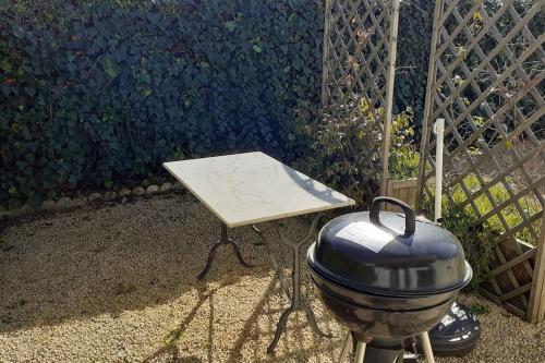 - un barbecue installé à côté d'une table dans un jardin dans l'établissement studio situé à Argeles gazost proche de gavarnie, à Argelès-Gazost