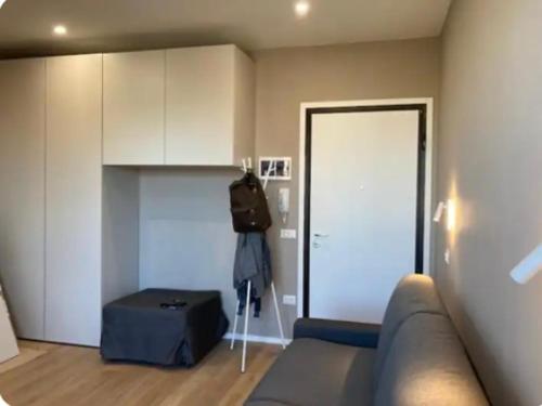a living room with a couch and a room with a door at Monolocale nuovo arredato vista mare in Valverde