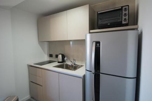a kitchen with a white refrigerator and a microwave at Espacio nuevo, tranquilo y céntrico en Bariloche in San Carlos de Bariloche
