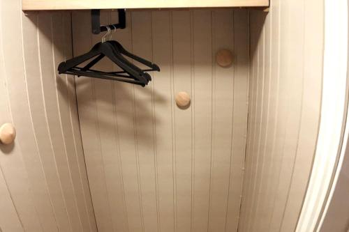 a bathroom with a white tiled wall with a hanger at Leilighet sentralt på Andenes med egen inngang in Andenes