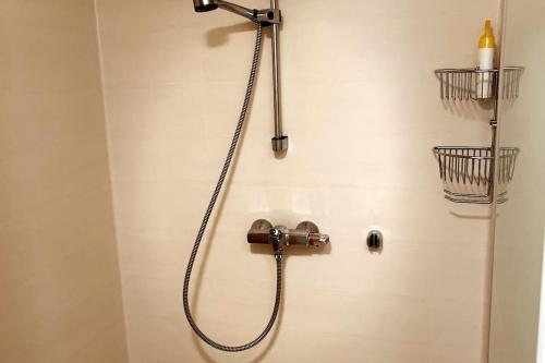a shower with a shower head in a bathroom at Leilighet sentralt på Andenes med egen inngang in Andenes